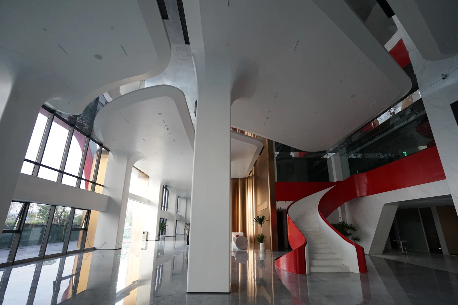Branching feature columns beside a red and white curved staircase