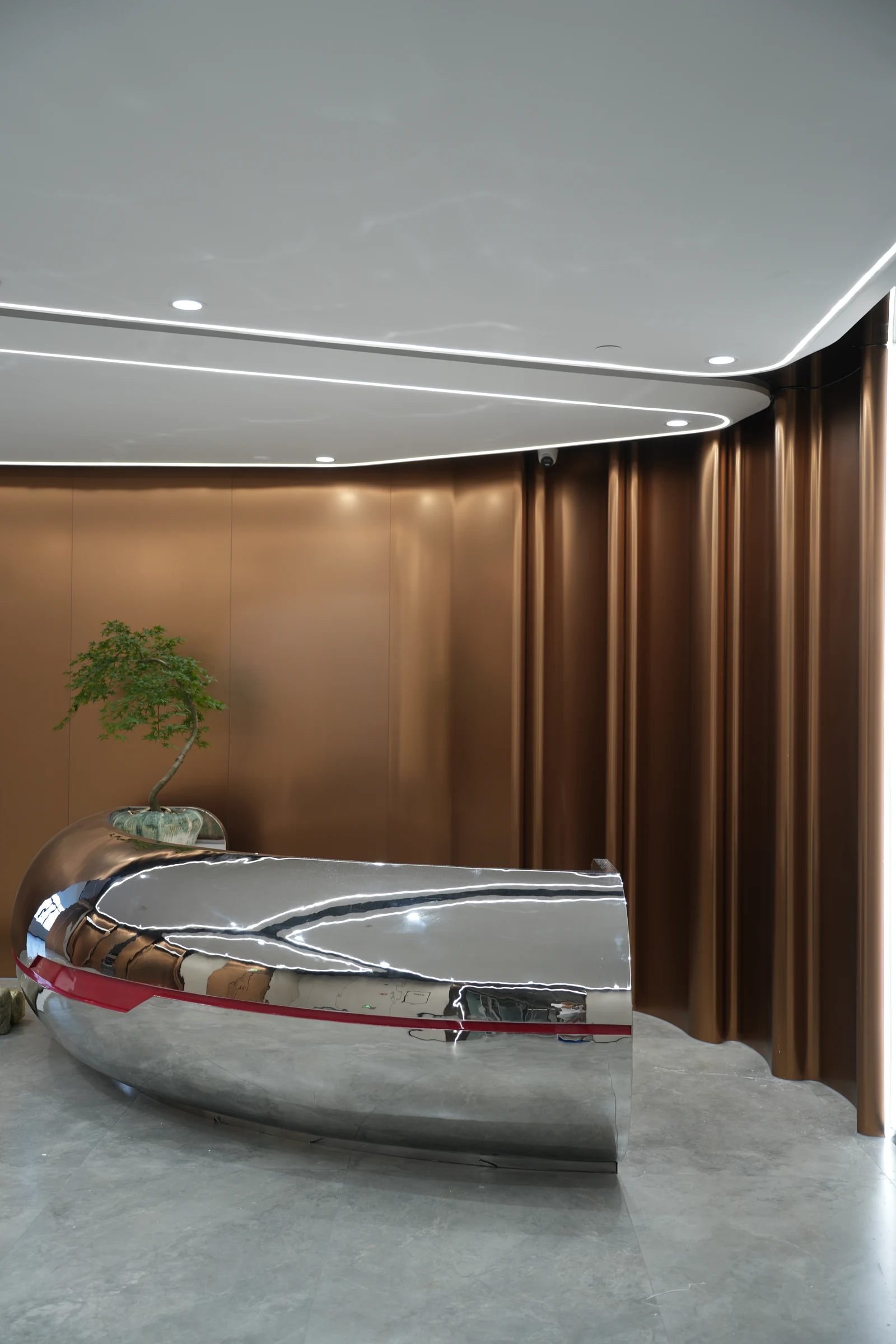 Curved metal wall and mirror-finish compound-curved feature counter in a completed interior