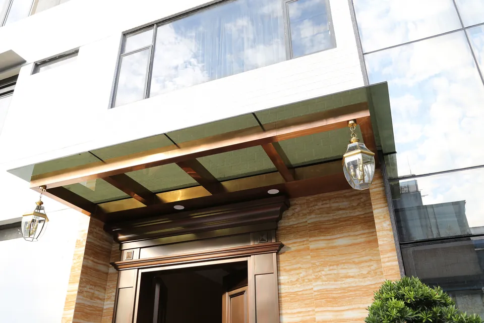 Completed glazed entrance canopy with bronze-toned framing at Poly Xiangxueshan Villa.