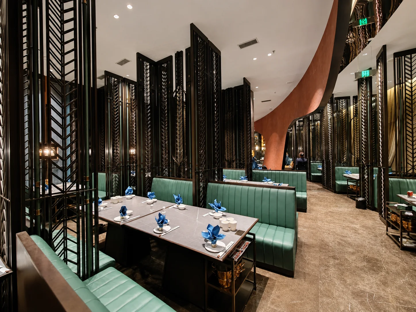 Modern hospitality interior with open metal screens separating dining booths from circulation