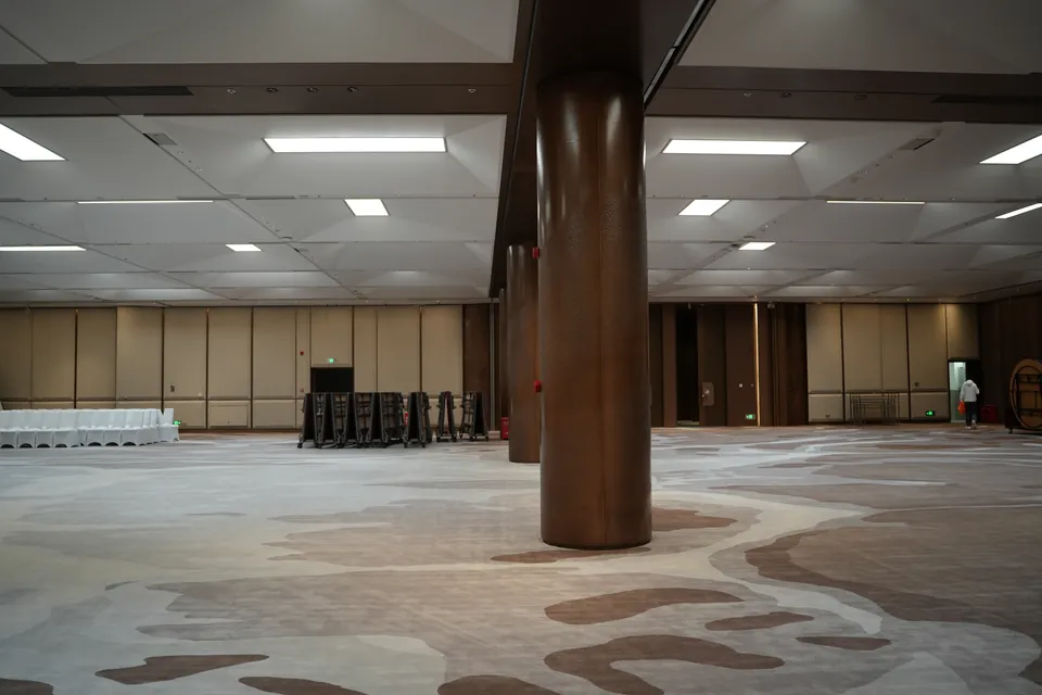 Completed large event hall with bronze-toned columns and wall panels in Shantou.