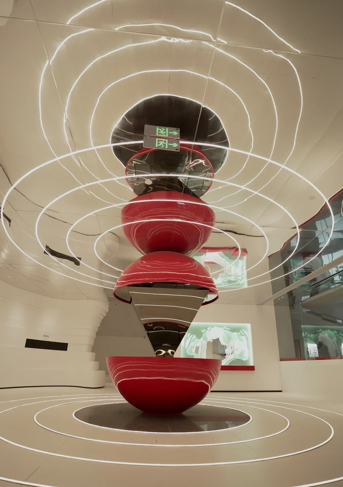Completed interior view of suspended red components beneath mirrored surfaces and circular lighting at Yunan Office Building, Guangzhou.