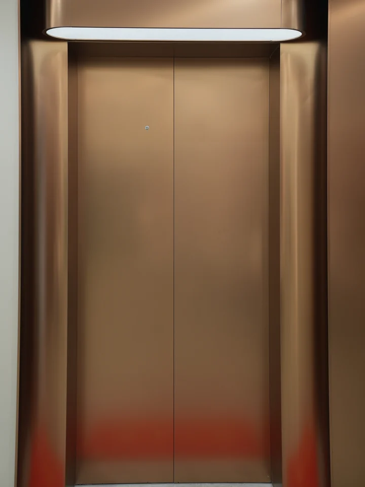 Completed portal detail showing metal seams, integrated lighting and the door surface at Yunan Office Building, Guangzhou.