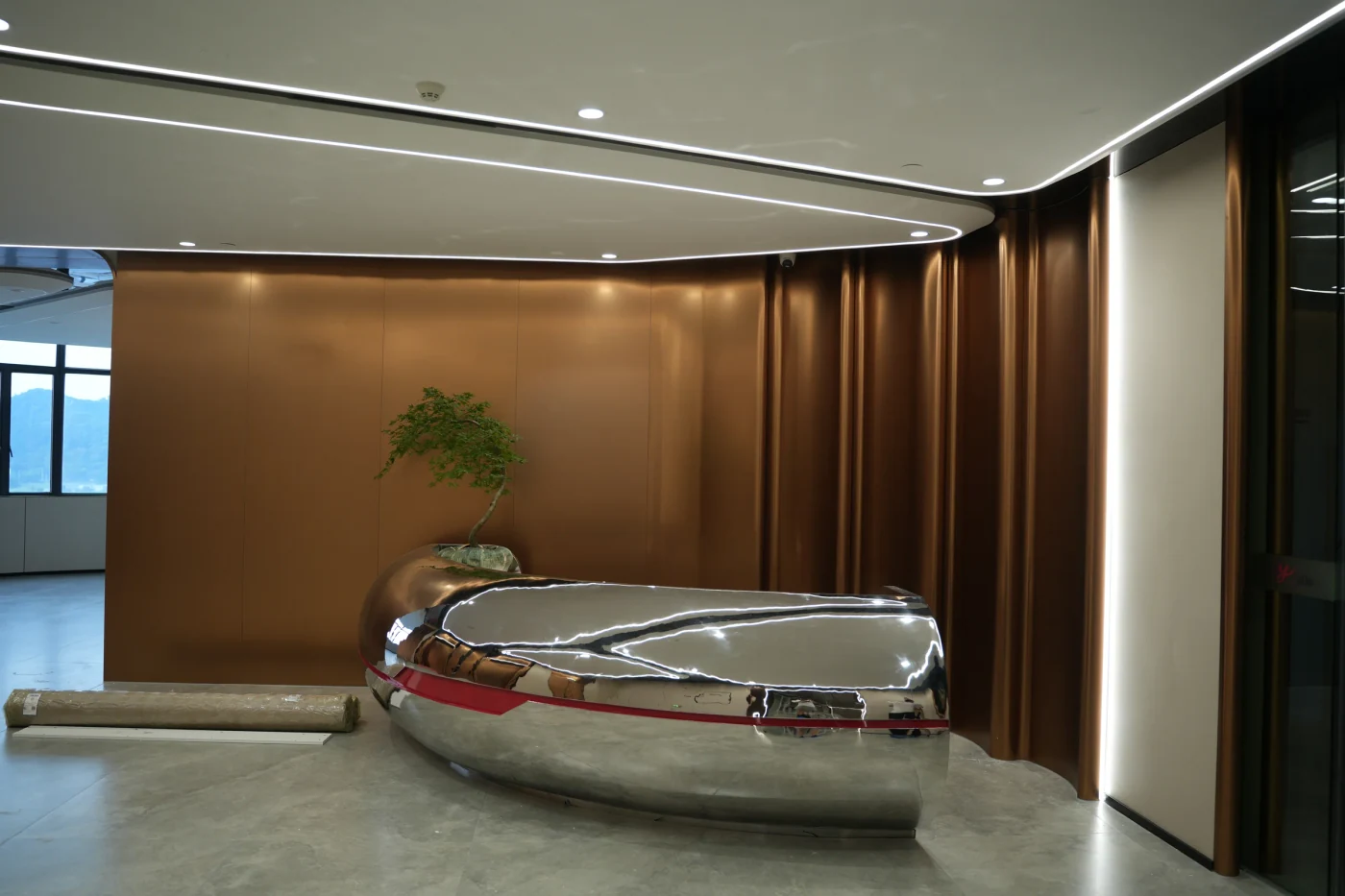 Bronze-toned wall panels and sculptural seating at Yunan Office Building, Guangzhou.