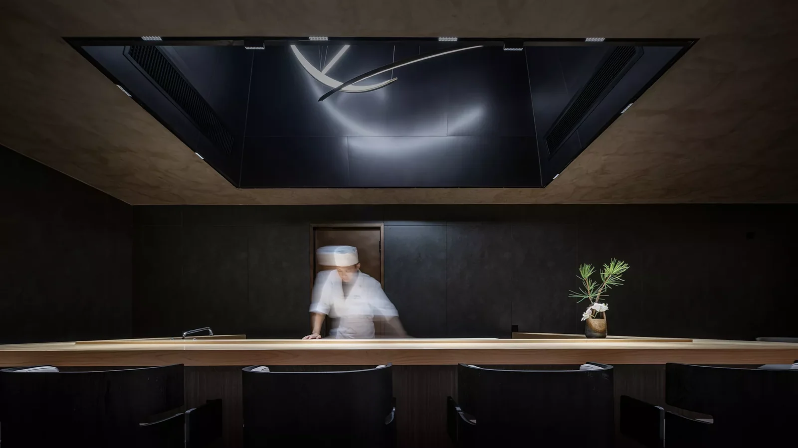 Dark reflective ceiling panels framed by a warm-toned restaurant interior.