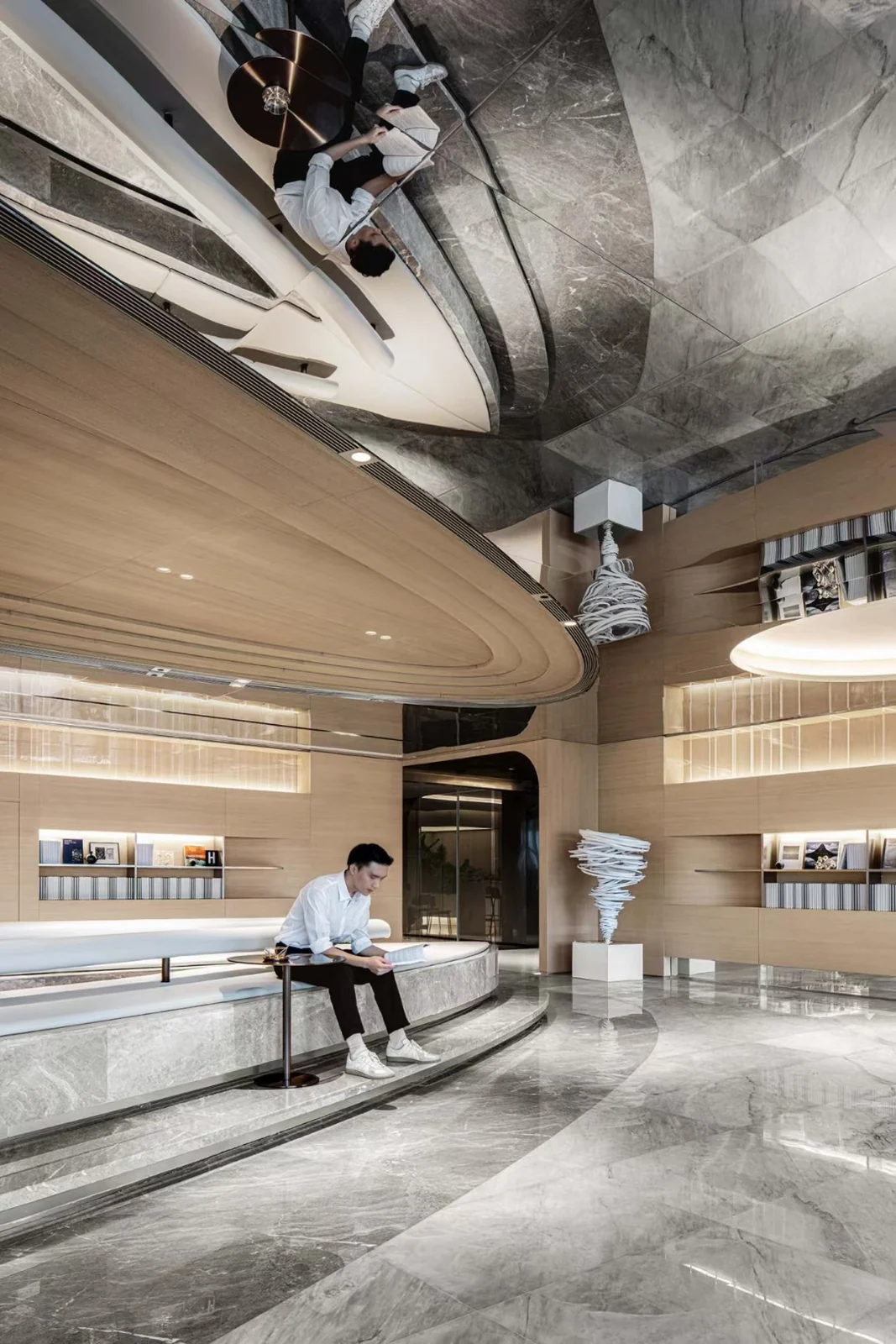 Reflective ceiling panels extending over a curved seating area.