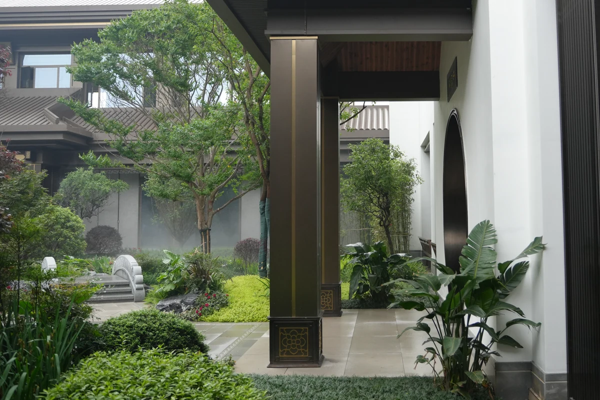 Frontal view of a square column at Hengshan Yuexiufu, showing its upright body, gold trim and patterned base beside the courtyard walkway