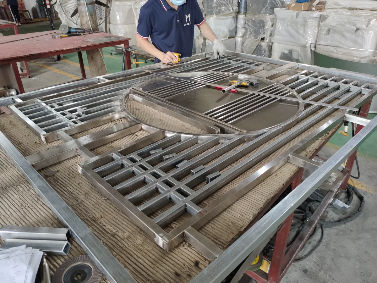 LMC workshop technician setting out and assembling a large metal screen frame